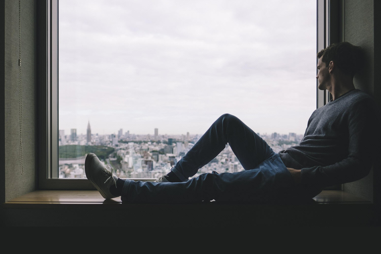 Reclining man looking out of window